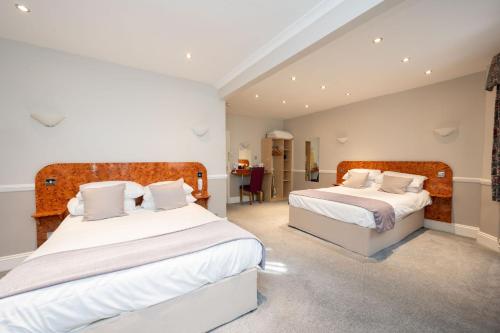 a bedroom with two beds with white sheets at The Lanes Hotel in Brighton & Hove