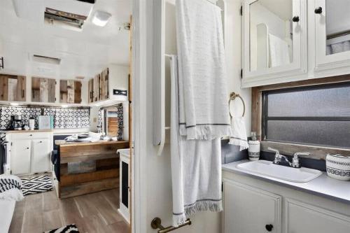 eine Küche mit weißen Schränken, einem Waschbecken und einem Fenster in der Unterkunft #StayinMyDistrict Twin Falls Backyard Glamper in Twin Falls