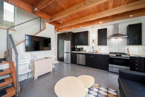 a kitchen with black and white appliances and a table at #StayinMyDistrict Buckman Open Loft-Style Townhome in Portland
