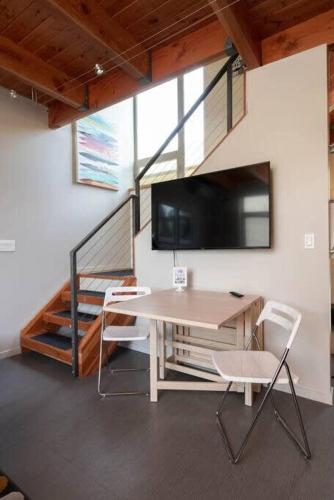 a room with a table and two chairs and a tv at #StayinMyDistrict Buckman Open Loft-Style Townhome in Portland