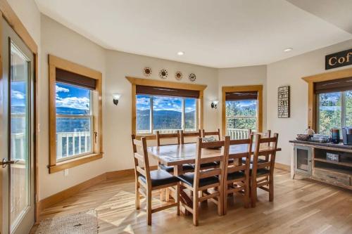 a dining room with a table and chairs and windows at Mountain Retreat Sauna Deck Views Sleeps 10 in Black Hawk