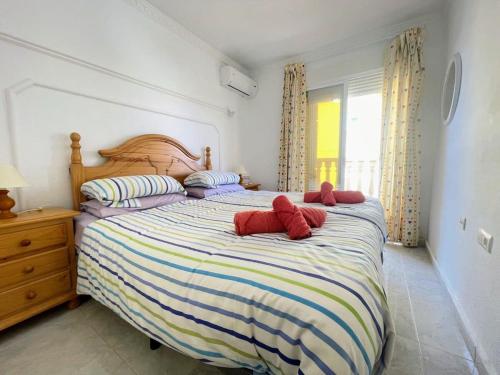 una camera da letto con un grande letto con animali rossi di peluche di Pleasant 4 Bedroom Townhouse with Com Pool VM7 a Orihuela