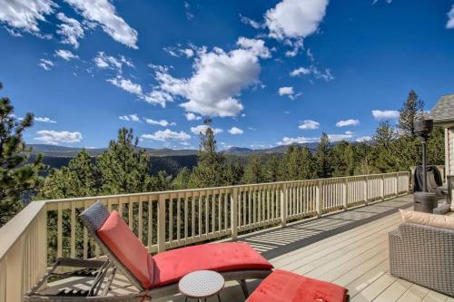 a deck with a red chair and a view of the mountains at Mountain Retreat Sauna Deck Views Sleeps 10 in Black Hawk