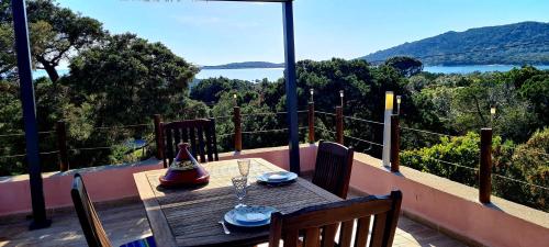 une table sur un balcon avec vue sur l'eau dans l'établissement Bergerie, vue mer exceptionnelle, à Pianottoli-Caldarello