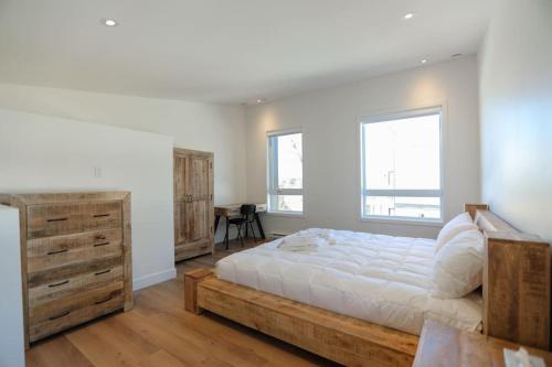 una camera con un grande letto e un comò in legno di Chalet Élios a Brownsburg