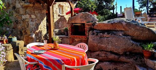 d'une table, de chaises et d'un four en pierre. dans l'établissement Bergerie, vue mer exceptionnelle, à Pianottoli-Caldarello