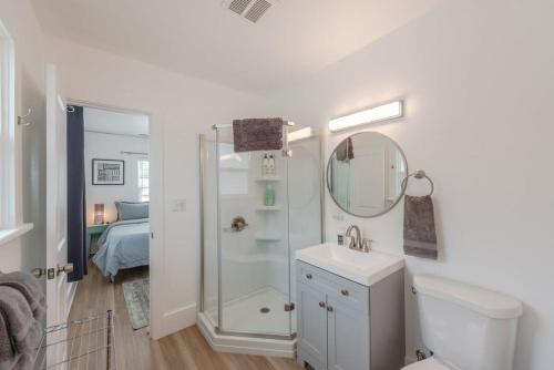 a white bathroom with a shower and a sink at #StayinMyDistrict Goldfinch Cottage Coos Bay in Coos Bay