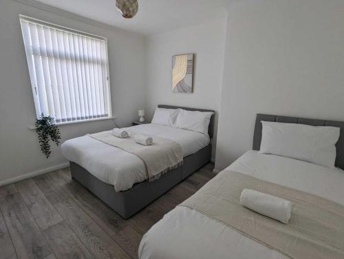 um quarto com 2 camas e uma janela em Alexander Apartments Dudley em Seaton Burn