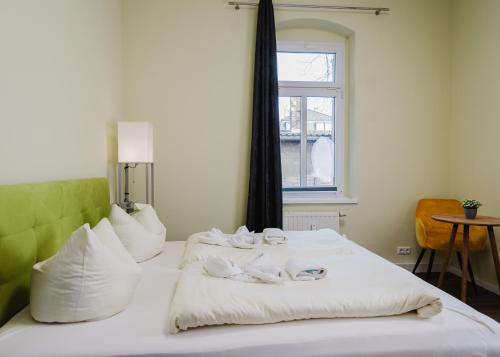 Cama blanca con almohadas blancas y ventana en Apartmenthaus Sternstraße en Dresden