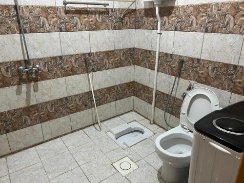 a bathroom with a toilet and a shower at شقق ذوق الخيآل المخدومه الحبله in Abha