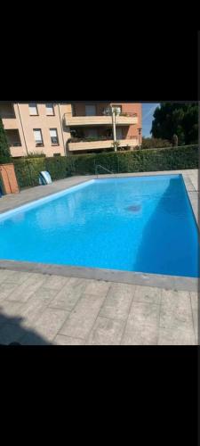 une grande piscine bleue devant un immeuble dans l'établissement Joli T2, jacuzzi, lit rond, jardin, parking privé, métro, à Toulouse