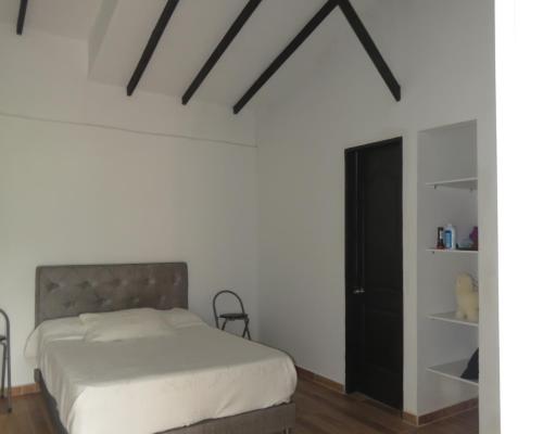 a bedroom with a bed and a black closet at HOTEL PURA VIDA in Santa Rosa de Cabal