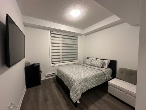 a small bedroom with a bed and a window at Keppel Circle Residence in Brampton