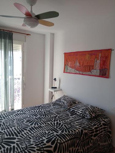 a bedroom with a black and white bed with a ceiling fan at CANETSOL in Canet de Berenguer