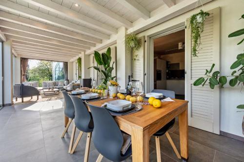 a dining room with a wooden table and chairs at Villa Artista in Gardone Riviera