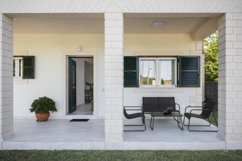 een terras met twee stoelen, een tafel en een raam bij Conte Marco in Mesongi