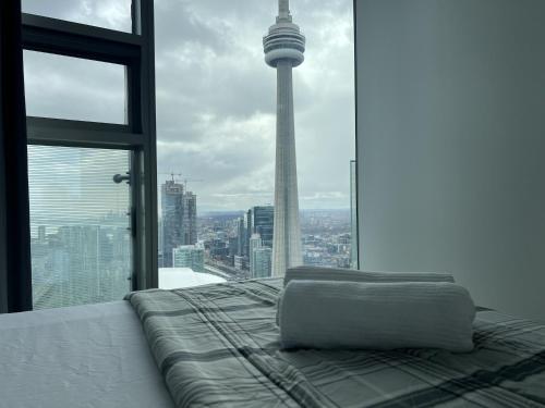 a bed in a room with a view of the seattle tower at Prime Stay Suites in Toronto
