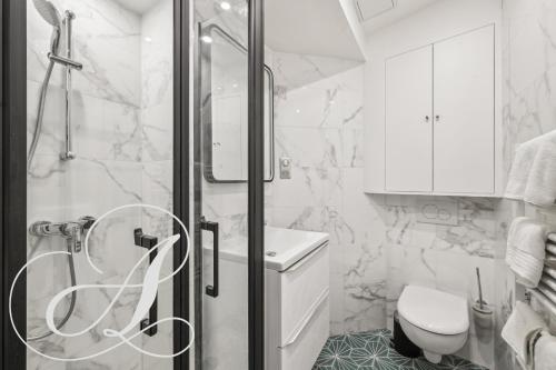 une salle de bain blanche avec douche et toilettes dans l'établissement Oasis, superbe appart 3 chambres à Paris 15ème, à Paris