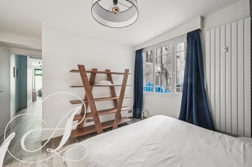 - une chambre avec un lit blanc et des rideaux bleus dans l'établissement Oasis, superbe appart 3 chambres à Paris 15ème, à Paris