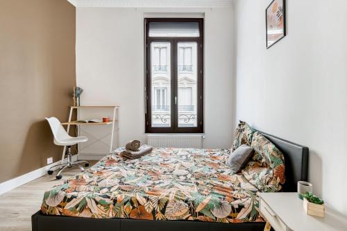 a bedroom with a bed and a desk and a window at Néfertiti - 3 chambres spacieuses in Saint-Étienne