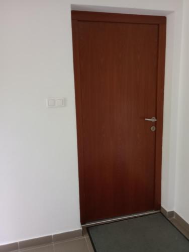 eine Holztür in einem Zimmer mit weißen Wänden in der Unterkunft Toboz41apartman in Budapest