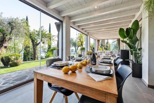 a dining room with a wooden table and chairs at Villa Artista in Gardone Riviera
