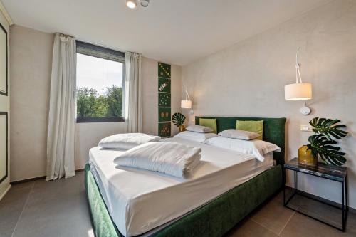 a bedroom with a large bed and a window at Villa Artista in Gardone Riviera