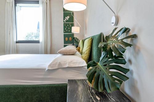 a bedroom with a bed and a potted plant at Villa Artista in Gardone Riviera