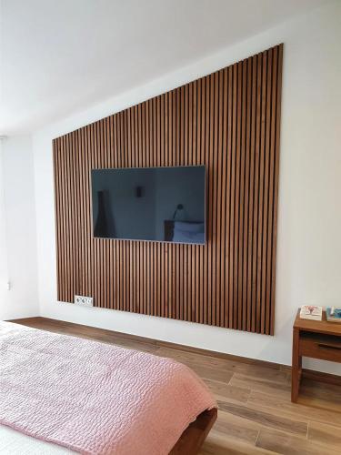 einen Flachbild-TV an der Wand in einem Schlafzimmer in der Unterkunft Pension Südheide in Wietze