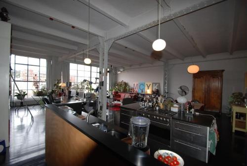 - une grande cuisine avec un comptoir dans une pièce dans l'établissement Loft d'exception, porte de Paris, à Ivry-sur-Seine