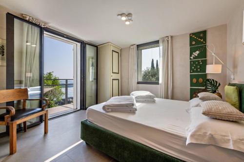 a bedroom with a large bed and a large window at Villa Artista in Gardone Riviera