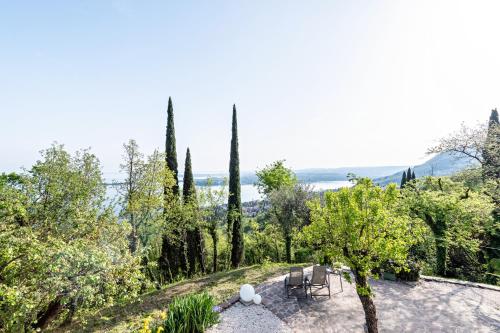 a view of a garden with trees and chairs at Villa Artista in Gardone Riviera
