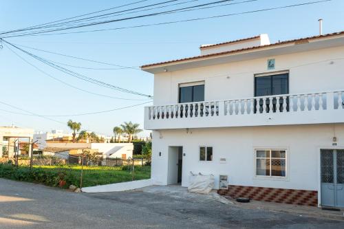 Cette maison blanche dispose d'un balcon. dans l'établissement BLife Marya private rooms, à Faro