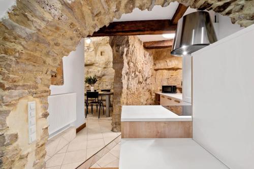 uma cozinha com uma parede de pedra e uma mesa em Peaceful Getaway in the Heart of the City ID229 em Luxemburgo