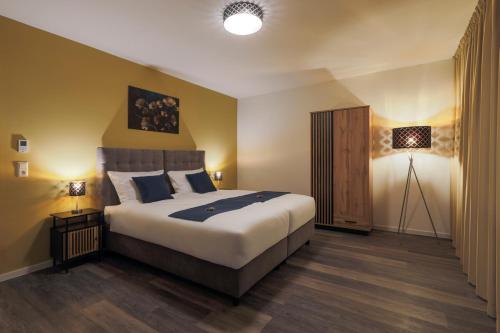- une chambre avec un grand lit et deux lampes dans l'établissement VIU2 Suites, à Hanovre