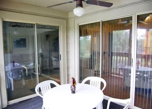 a white table and chairs on a porch with sliding glass doors at Heron Lake 3232 in North Myrtle Beach