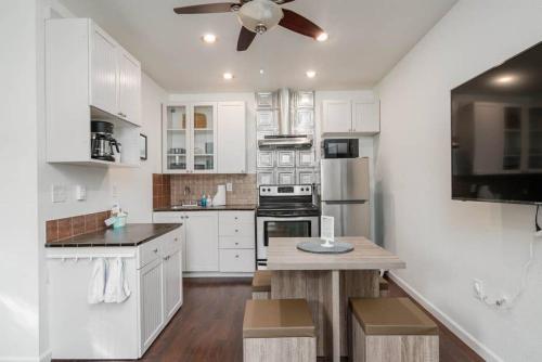 a kitchen with white cabinets and a ceiling fan at #StayinMyDistrict Kenton Private Guest House in Portland