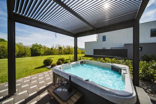 d'un bain à remous installé sur une terrasse avec un toit. dans l'établissement K Relax Place, Varaždinske Toplice, modern home with Sauna, Jacuzzi, WIFI, à Varaždinske Toplice