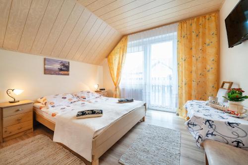 a bedroom with two beds and a large window at Nasz Bosman in Jastarnia