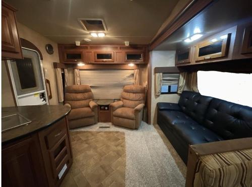 a living room with a couch and chairs in a rv at LOVELY RV in Dallas
