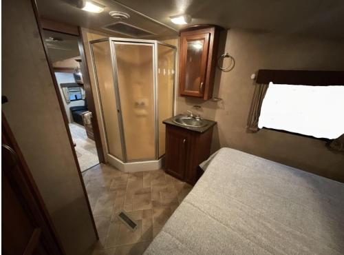 a small bathroom with a shower and a bed at LOVELY RV in Dallas
