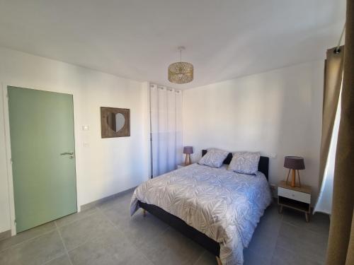 une chambre avec un lit dans une pièce blanche dans l'établissement Beaux Souvenirs, à Boujan-sur-Libron