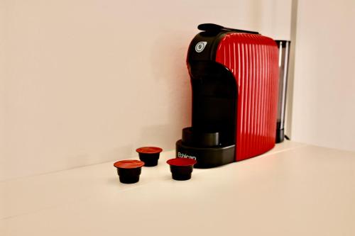 a red suitcase and three red cups on a counter at La Casa di Cloe in La Spezia