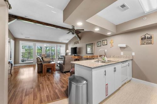 a kitchen and living room with a counter and a table at Penthouse Thousand Hills Golf Front Condo with Pool close to 76 and Sleeps 8 in Branson
