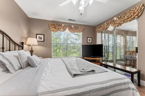 a bedroom with a white bed and a large window at Penthouse Thousand Hills Golf Front Condo with Pool close to 76 and Sleeps 8 in Branson