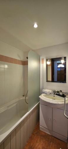 a bathroom with a sink and a bath tub and a mirror at Mini Caseddu T2, Alba Rossa avec Piscine & vue mer in Serra-di-Ferro