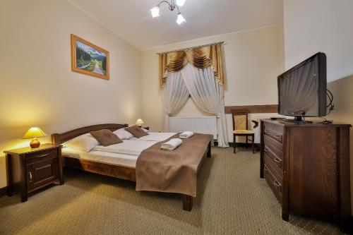 a bedroom with a bed and a flat screen tv at Willa Bella in Zakopane