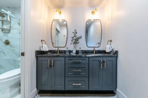 a bathroom with two sinks and two mirrors at Stylish 2BD Condo - Walk to Palisades! in Olympic Valley