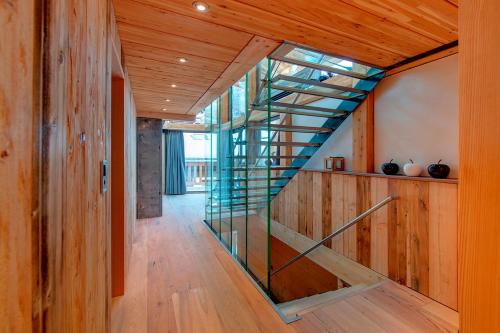 a glass staircase in a room with wooden walls at Luxury Chalet by Heinz Julen in Zermatt