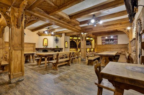 a large room with wooden tables and benches at Willa Bella in Zakopane